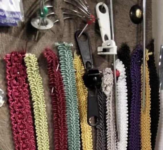 Gajtani i ukrasne trake različitih boja na vešalici